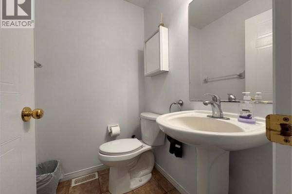 A powder room with a white pedestal sink, toilet, and a mirrored medicine cabinet on a light gray wall. - 772 Zermatt Drive, Waterloo