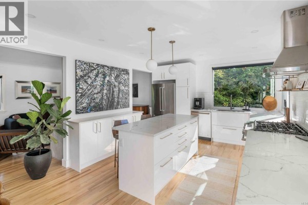 Contemporary kitchen with white cabinets, island, stainless steel appliances, and a large window. - 773 Middleton St, Saanich