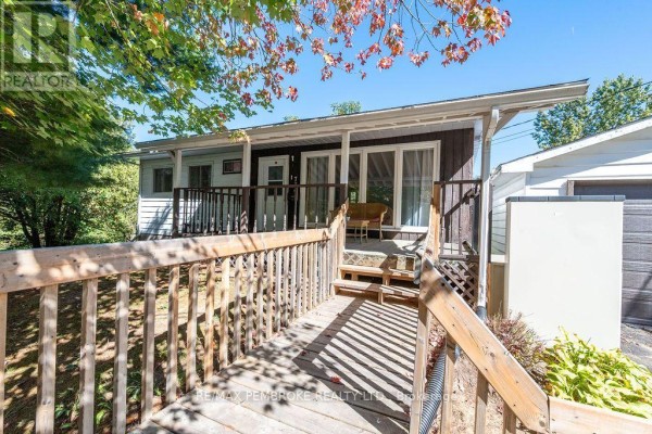 Wooden ramp leading to a covered front porch with a seating area. - 774 Pinegrove Crescent, Petawawa