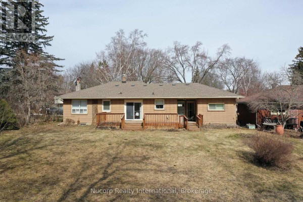Rear exterior of the house showing a wooden deck and backyard with trees. - 774 Sutherland Avenue, Newmarket