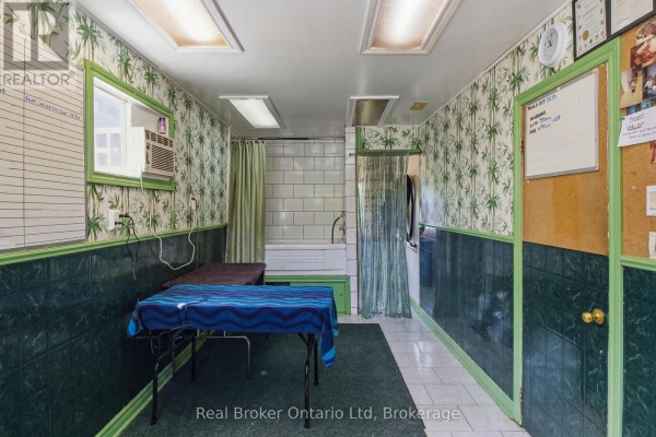 Interior hallway with tiled floor, featuring dark credenzas, decorative lamps, and white doors. - 775498 10 Highway N, West Grey