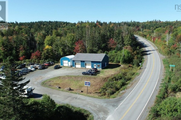 Aerial view of a blue commercial building with two garage bays and an attached arched structure. - 7756 Highway 276, Lot 1, Roachvale