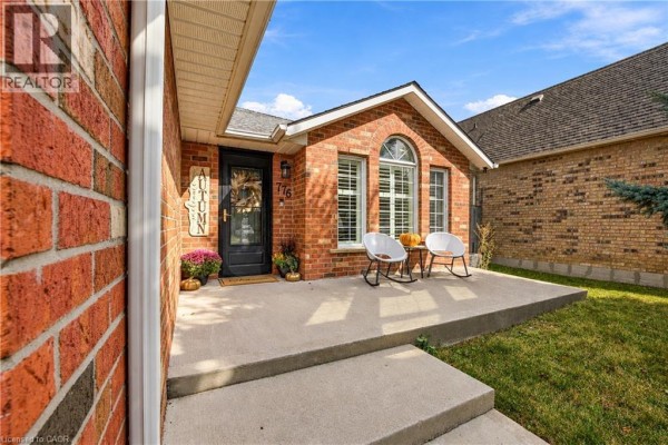 Front door porch with two white chairs and pumpkins by the entrance. - 776 Acadia Drive, Hamilton