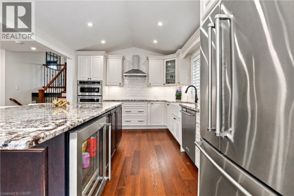 Kitchen with island, wine fridge, stainless steel appliances, and subway tile backsplash. - 776 Acadia Drive, Hamilton