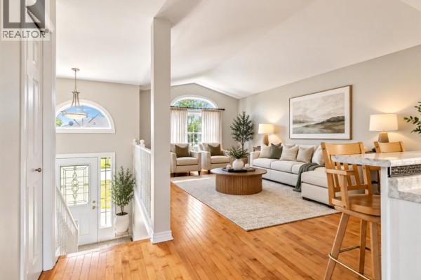Living room with a curved sofa, two accent chairs, and large gray curtains. - 776 Dynasty Street, Windsor