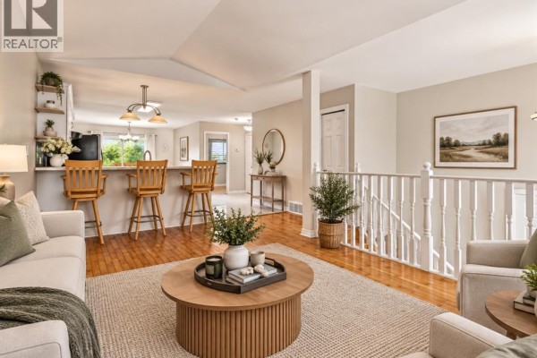 Bedroom with a queen-size bed, accent chair, two nightstands, and modern art. - 776 Dynasty Street, Windsor