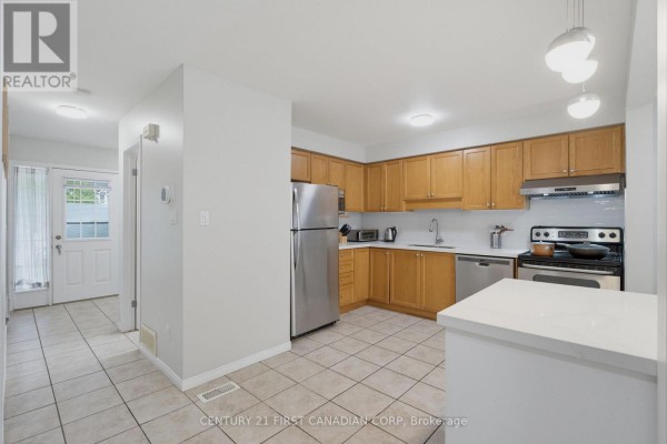 Kitchen with light wood cabinets, stainless steel appliances, and a white island. - 776 Silversmith Street, London North