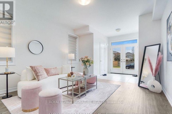 Living room with white sectional sofa, glass coffee table, and double doors opening to outside. - 7763 Secretariat Court, Niagara Falls