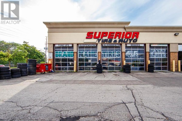 Close-up exterior view of "Superior Tire & Auto" with garage doors and stacked tires. - 777 Dundas Street W, Mississauga