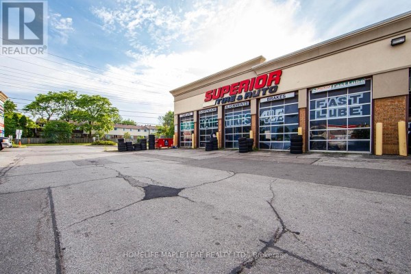 Exterior view of a commercial building housing "Superior Tire & Auto" with garage doors. - 777 Dundas Street W, Mississauga