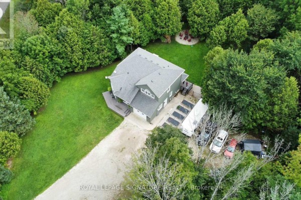 Rear view of the grey house with a spacious wooden deck and backyard. - 777320 Highway 10, Chatsworth