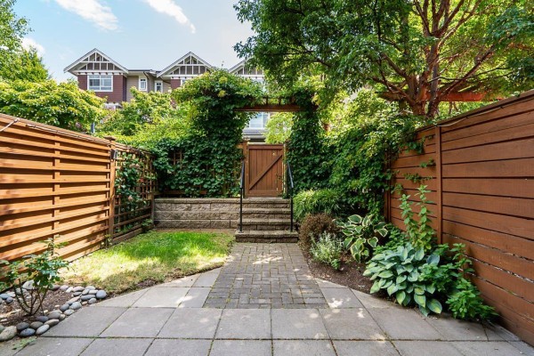Paved patio with wooden fences in front of a townhouse entrance. - 78 2979 156 Street, Surrey