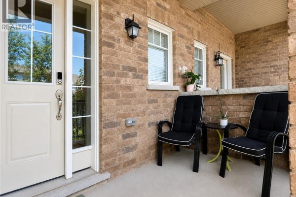 Front door of a townhouse with a glass pane, beige door, and brick exterior. - 78 Glenvista Drive Unit# Upper, Kitchener