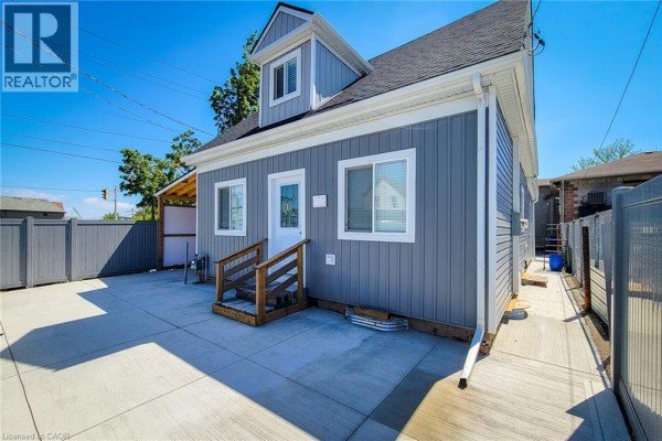Aerial view of a grey house with a fence surrounding the property, concrete driveway, and carport. - 78 Hillyard Street, Hamilton