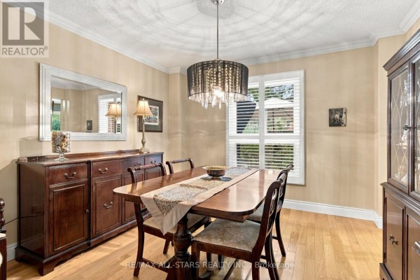 Dining room with a wooden table, chairs, buffet, glass cabinet, and chandelier. - 78 Tilman Circle, Markham