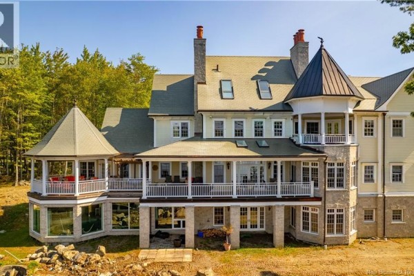 Rear exterior view of the large home showing covered wrap-around balconies and stone foundation. - 78 Todd's Point Road, Dufferin