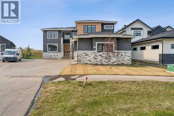 Front view of the house with a freshly sodded lawn and driveway. - 78 Trinity Road, Rural Rocky View County