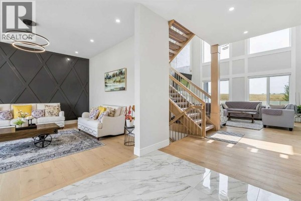 View of the living room, staircase, and open-concept main floor with high ceilings. - 78 Trinity Road, Rural Rocky View County