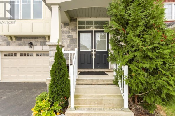 Close-up of the front entrance with double black doors, concrete steps, and white railings. - 7808 Tupelo Crescent, Niagara Falls
