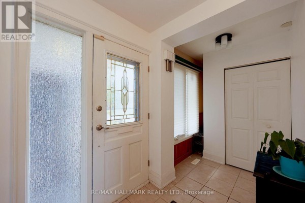 Interior entryway with a white door, frosted glass sidelight, and tiled floor leading to a closet. - 781 Pam Crescent, Newmarket