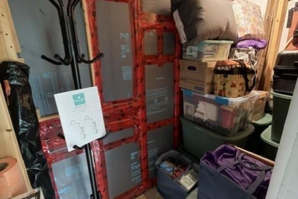 A cluttered storage area with boxes, bags, and household items. - 7825 Route 3, Dewolfe