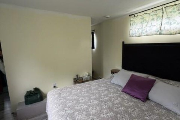 A bedroom with a queen-size bed, patterned duvet, and a black headboard. - 7825 Route 3, Dewolfe