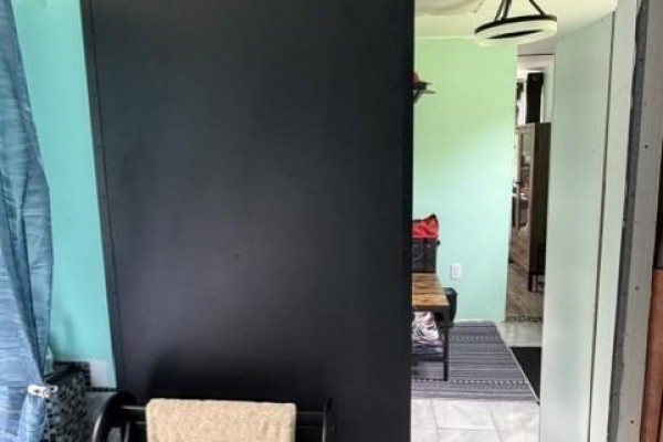 A hallway view into a room with green walls and a glimpse of furniture. - 7825 Route 3, Dewolfe