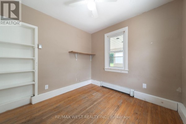 Bedroom with built-in shelving and wooden floors - 7826 Yonge Street Innisfil
