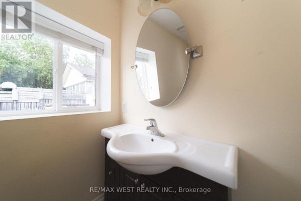 Oval mirror & vanity sink in bathroom - 7826 Yonge Street Innisfil