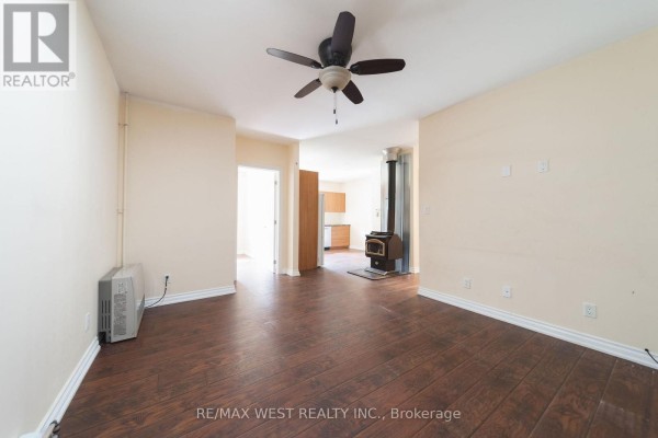 Living room with wood-burning stove & ceiling fan - 7826 Yonge Street Innisfil