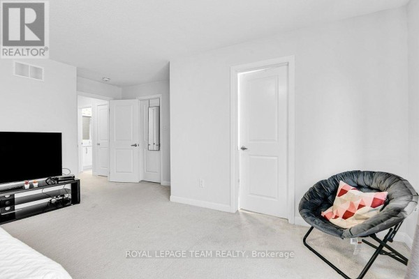 Modern bedroom with TV and accent chair - 784 Cappamore Drive Ottawa