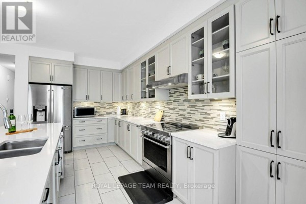 Modern kitchen with stainless steel appliances and white cabinets - 784 Cappamore Drive Ottawa