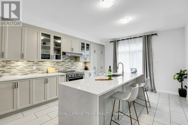 Modern kitchen with island, quartz countertop, and stainless steel appliances - 784 Cappamore Drive Ottawa