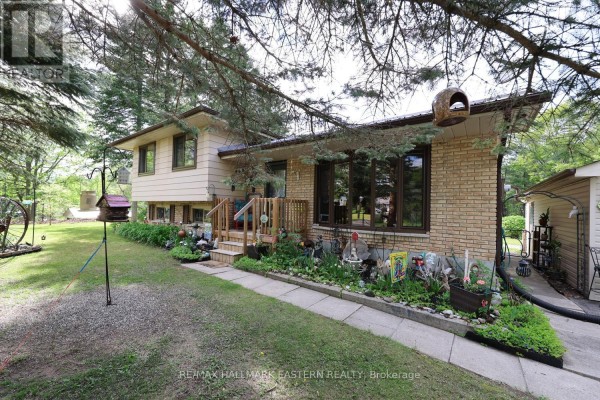 Front view of a house with beige siding, brick accents, and a covered porch with wooden railings. - 784 Old Norwood Road, Havelock Belmont Methuen