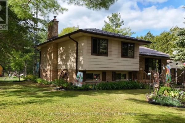 Side view of a house featuring beige siding, brickwork, and a pitched brown metal roof. - 784 Old Norwood Road, Havelock Belmont Methuen