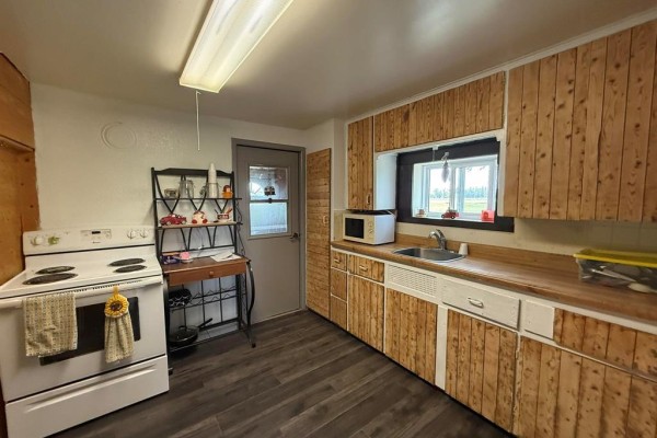 Utility room with a white washing machine, dryer, and wooden cabinets on the wall. - 785 Bond Street, Cartwright