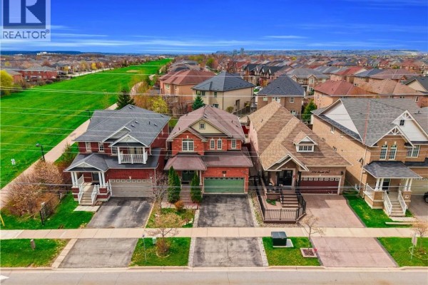 Aerial view of suburban houses with green fields beyond under blue sky. - 786 Fourth Line, Milton