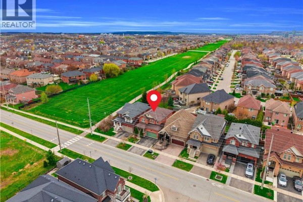 High aerial view of houses along a suburban street next to a long green field. - 786 Fourth Line, Milton