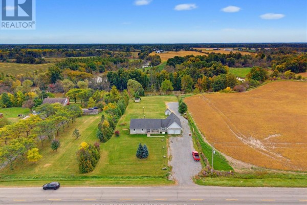 Aerial view of a rural property with a house, garage, and surrounding fields. - 7877 Canborough Road, Haldimand