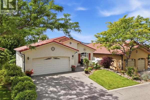 Exterior view of a stucco house with a red tile roof, showing a double garage and a single garage. - 788 Rosewood Crescent, Kamloops