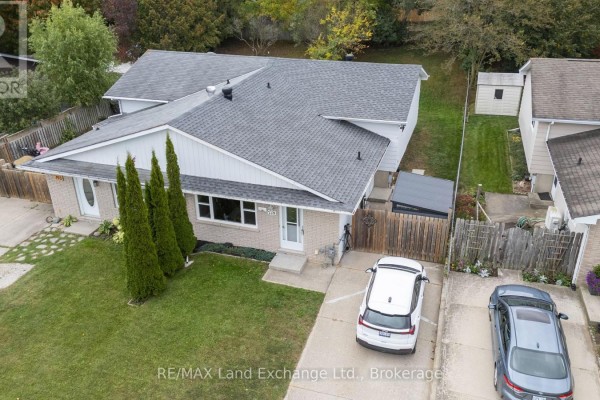 Aerial view of a bungalow at 789 Eastwood Drive with a driveway and two parked cars. - 789 Eastwood Drive, Saugeen Shores