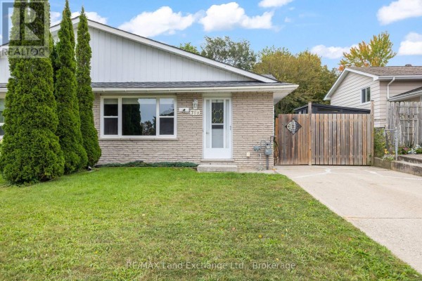 Front exterior view of a light brick bungalow with a concrete driveway and green lawn. - 789 Eastwood Drive, Saugeen Shores