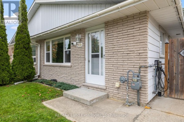 Close-up exterior view of the front door and light brick facade of a bungalow. - 789 Eastwood Drive, Saugeen Shores