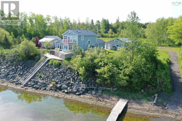 Aerial view of two residential houses on a rocky shoreline with water in the foreground. - 79 & 81 Oak Lane, Loch Broom Loop, Loch Broom Loop