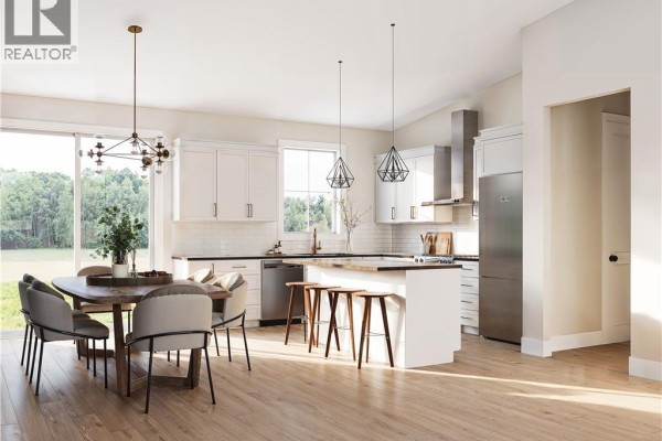Open-concept kitchen and dining area with white cabinets, stainless steel appliances, and wooden floors. - 79 Baron Street, Barachois