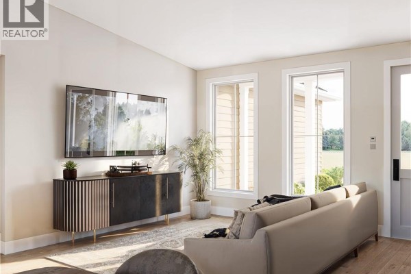 Living room with a large television on a dark wood cabinet and a sectional sofa. - 79 Baron Street, Barachois