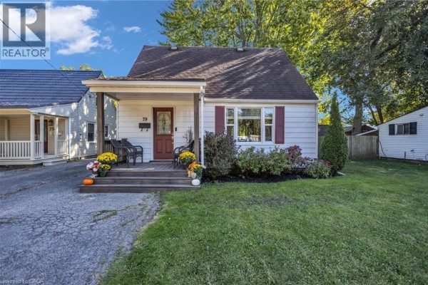Front view of a small white house with a covered porch and red door. - 79 Brydges Street, Stratford