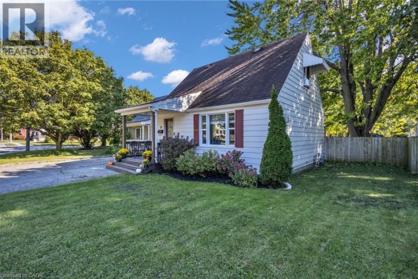 Side view of a white house with a peaked roof and surrounding greenery. - 79 Brydges Street, Stratford