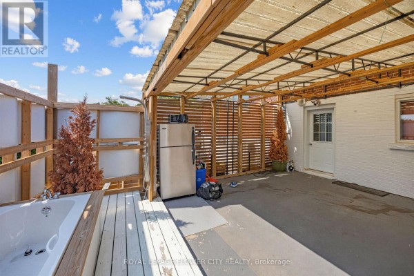 Outdoor hot tub and shower with refrigerator on a covered patio - 79 Kimberly Drive Hamilton