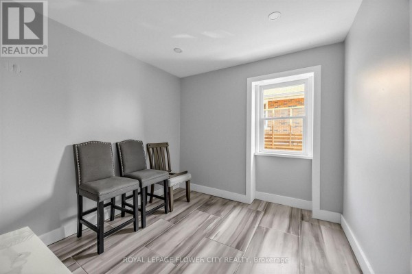 Two upholstered bar stools and a wooden stool in a room with tiled floors and a window - 79 Kimberly Drive Hamilton
